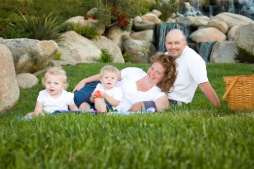 Happy Young Family with Twins Portrait in Park