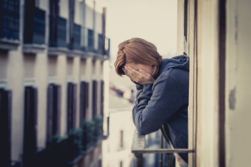 young woman suffering depression and stress outdoors at the balcony