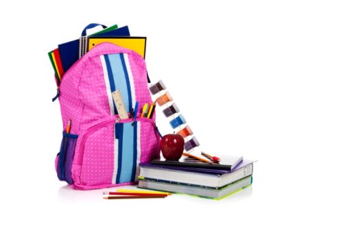 Pink backpack with school supplies with copy space
